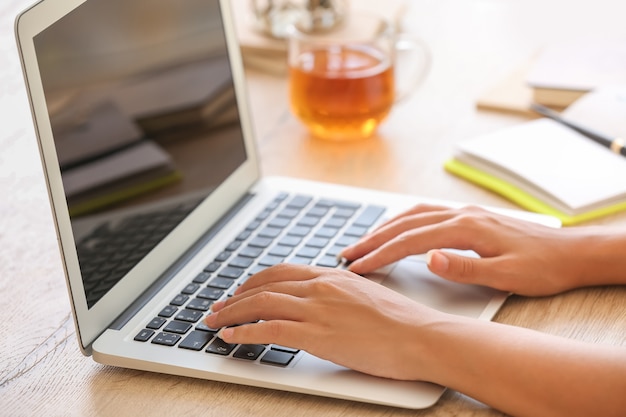 Afro-Amerikaanse vrouw die op laptop thuis werkt