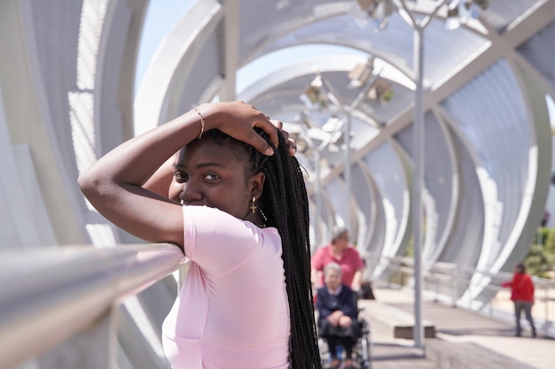 Afro-Amerikaanse vrouw die zich voordeed terwijl ze naar de camera kijkt met doosvlechten