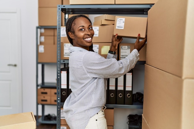 Afro-Amerikaanse vrouw e-commerce zakelijke werknemer met pakket rekken op kantoor