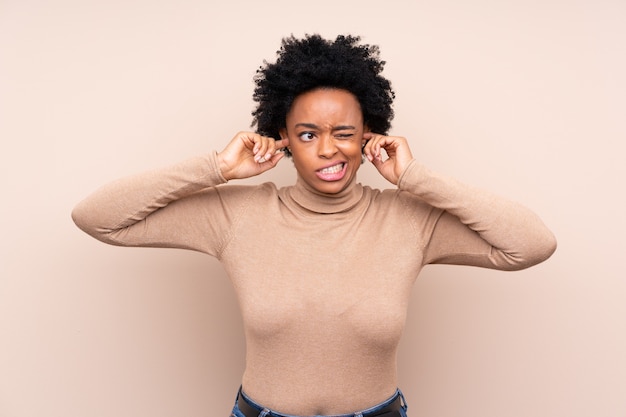 Foto afro-amerikaanse vrouw geïsoleerde achtergrond gefrustreerd en bedekkende oren