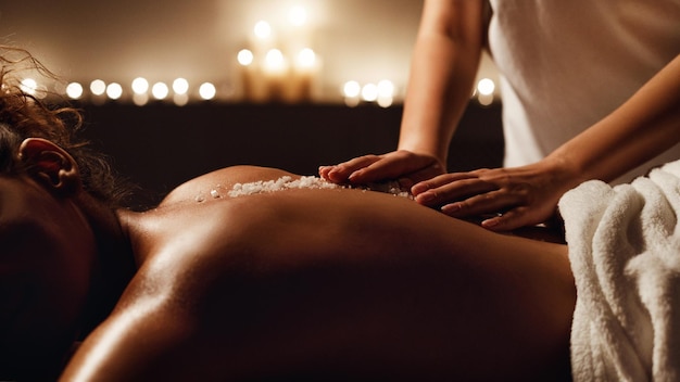 Afro-Amerikaanse vrouw geniet van zout scrub massage in de spa