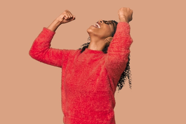 Afro-Amerikaanse vrouw in de studio die de vuist opheft na een overwinningsconcept
