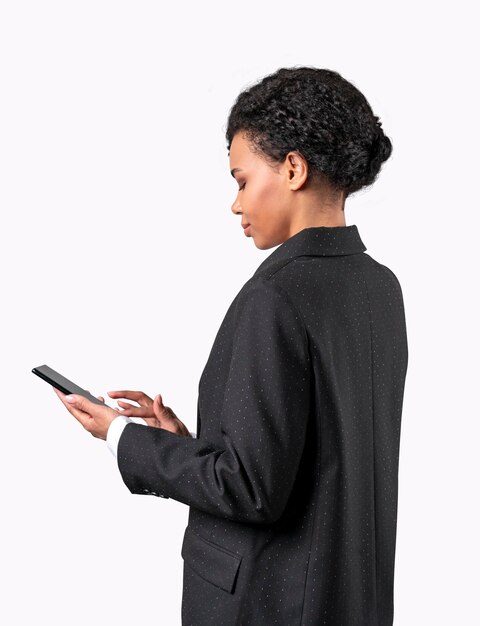 Afro-Amerikaanse vrouw in zwart pak kijken naar mobiele telefoon en sms'en Geïsoleerd op witte achtergrond