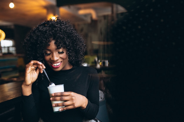 Afro-Amerikaanse vrouw koffie drinken in een café