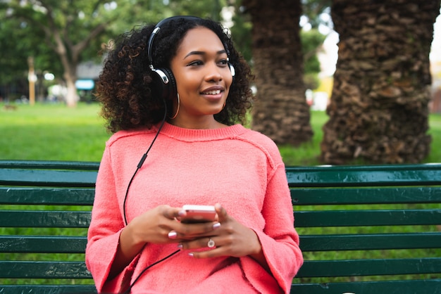 Afro-Amerikaanse vrouw luisteren muziek met telefoon