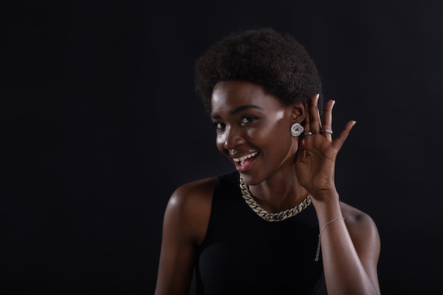 Afro-Amerikaanse vrouw luistert aandachtig en houdt hand op oor geruchten roddels en nieuw informatieconcept