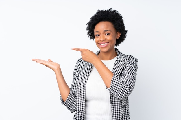 Afro-Amerikaanse vrouw met blazer op geïsoleerd wit copyspace denkbeeldig houden op de handpalm om een advertentie in te voegen