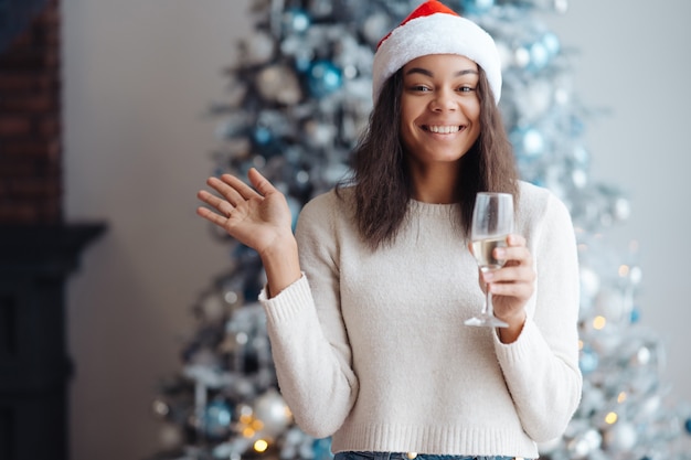 Afro-Amerikaanse vrouw met een glas champagne thuis