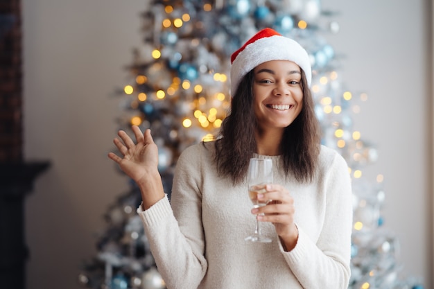 Afro-Amerikaanse vrouw met glas champagne thuis