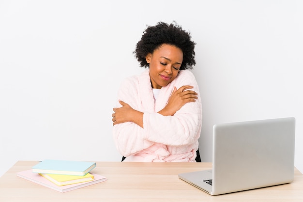 Afro-Amerikaanse vrouw van middelbare leeftijd thuis werken geïsoleerde knuffels, glimlachend zorgeloos en gelukkig.