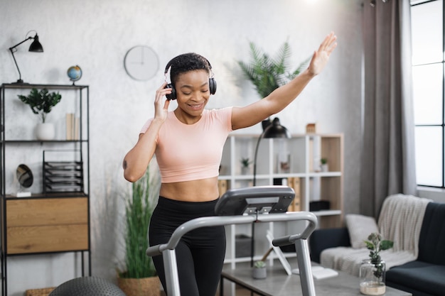 Afro-amerikaanse vrouwen met kort krullend haar in sportkleding en sneakers luisteren naar muziek