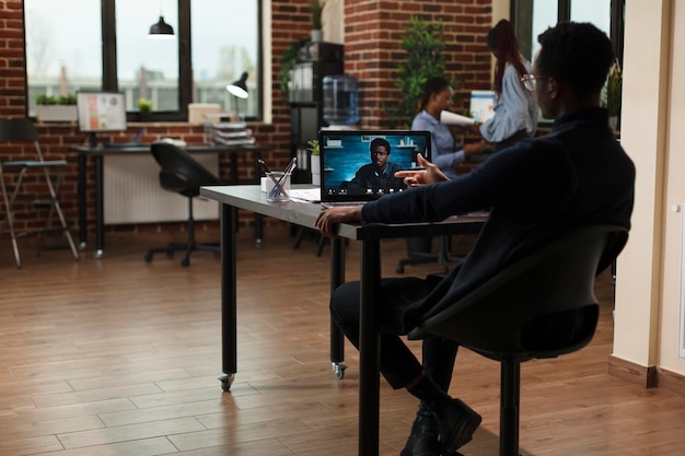 Afro-Amerikaanse zakenman in externe digitale teleconferentie met collega die over marketingstrategie bespreekt. Onderzoeksbureau teamleider op internet videogesprek met CEO praten over fondsen