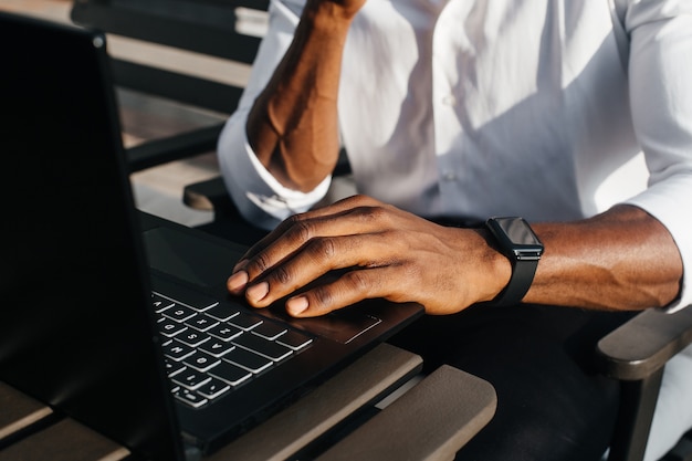 Afro-Amerikaanse zakenman werkt op een laptop in een café