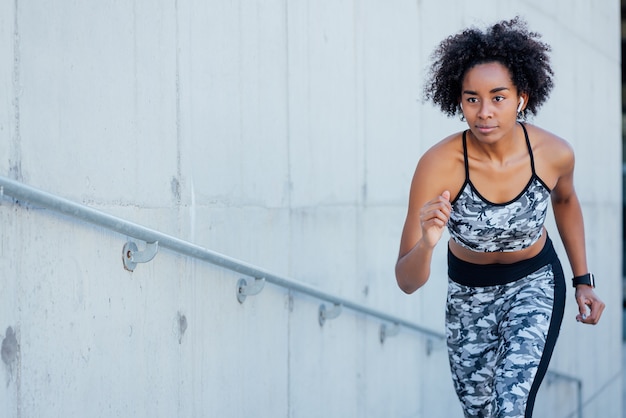 Photo afro athletic woman running and doing exercise outdoors