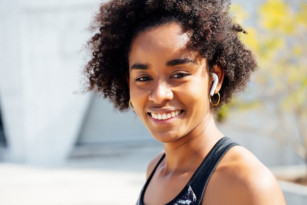 Afro atletische vrouw die zich buiten op straat bevindt. Sport en een gezonde levensstijl.