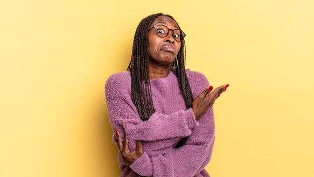 Bella donna afro nera che si sente confusa e incapace, chiedendosi una spiegazione o un pensiero dubbio