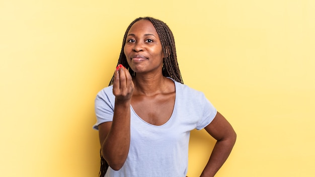 Afro black pretty woman making capice or money gesture, telling you to pay your debts!