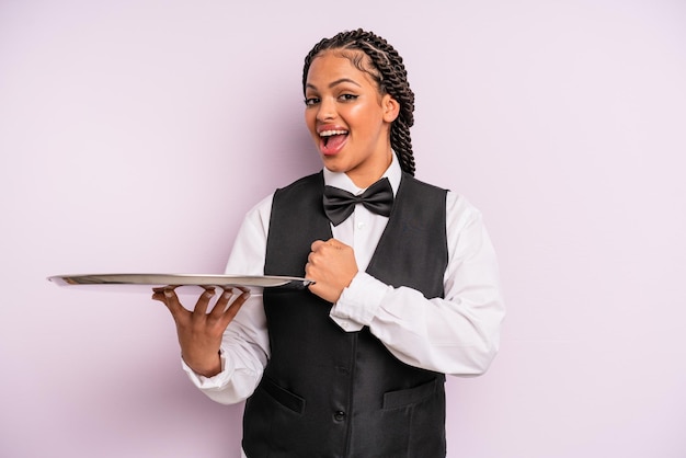 Foto donna di colore afro che si sente felice e affronta una sfida o festeggia. cameriere con vassoio