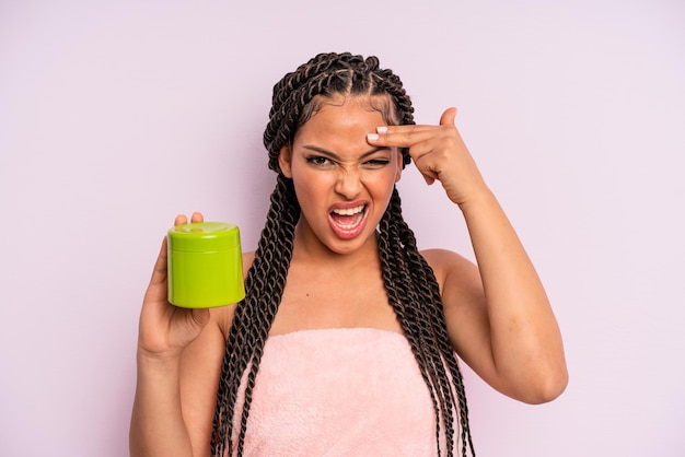 Afro black woman looking unhappy and stressed, suicide gesture making gun sign. hair treatment concept