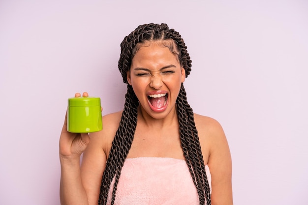 Afro black woman shouting aggressively looking very angry hair treatment concept