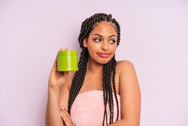 Afro black woman shrugging, feeling confused and uncertain. hair treatment concept