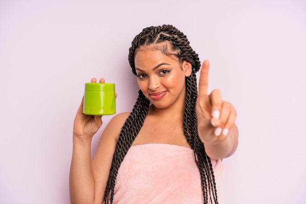 Afro black woman smiling proudly and confidently making number\
one hair treatment concept