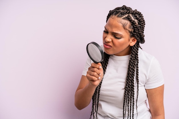 Afro black woman with braids with a magnifying glass