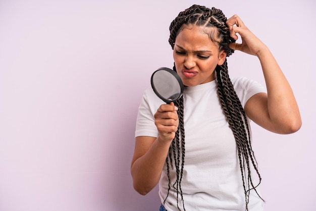 Afro black woman with braids with a magnifying glass