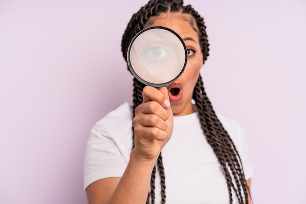 Afro black woman with braids with a magnifying glass