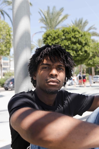 Afro boy looking at the camera while the sun shines on his face Vertical photo