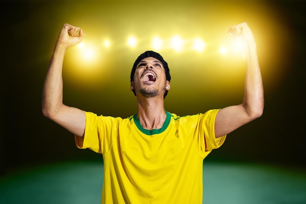 Afro-Braziliaanse man met geel shirt Voetbalteam voor de 2022 Cup juicht voor Brazilië om de kampioen te worden