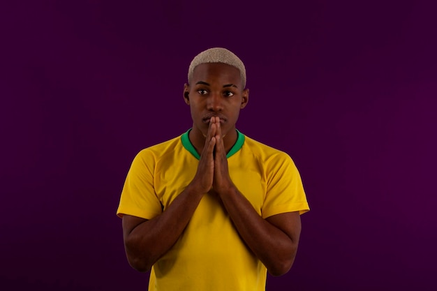 Afro brazilian man with the shirt of the brasilia soccer team for the 2022 cup in qatar