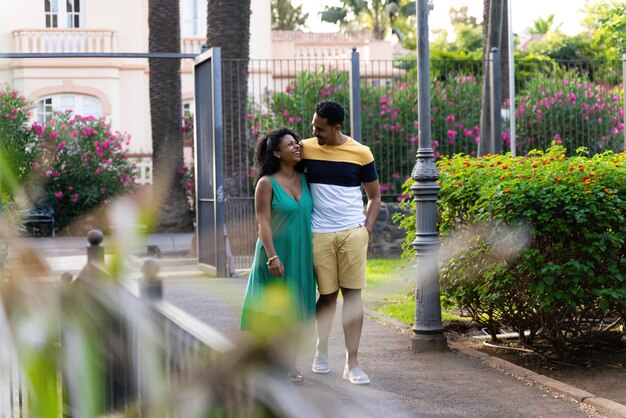 Afro bride and groom walking in the park