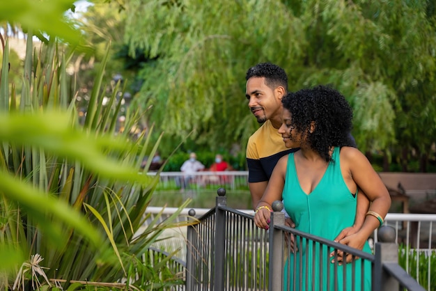 Afro bruid en bruidegom wandelen in het park