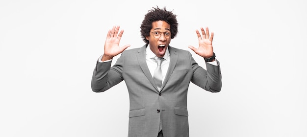 Afro businessman screaming in panic or anger, shocked, terrified or furious, with hands next to head