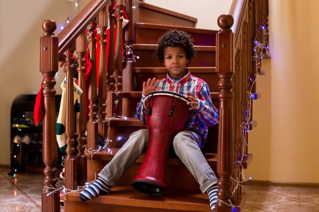 Afro child plays on drum kid with drum on christmas young percussion talent call it his first concert