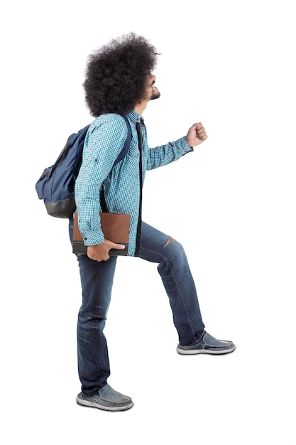 Afro college student poses step up on the staircase