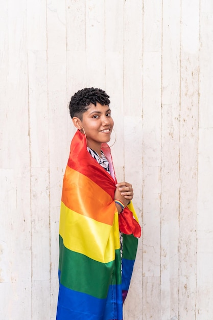 Afro Colombian woman with multicolored flag representing symbolic LGBTQ stripes