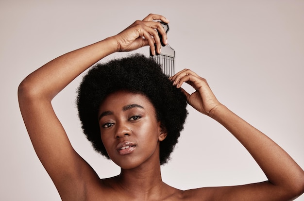 Afro comb black woman and portrait of a model with hair care salon and cosmetics Hairdresser comb African hairstyle and beauty of a young person doing a treatment for self care in a studio