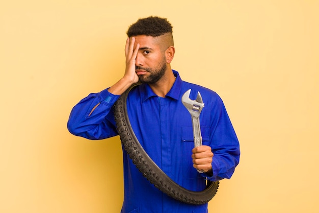 Foto uomo afro cool che si sente annoiato, frustrato e assonnato dopo un noioso concetto di riparatore di biciclette