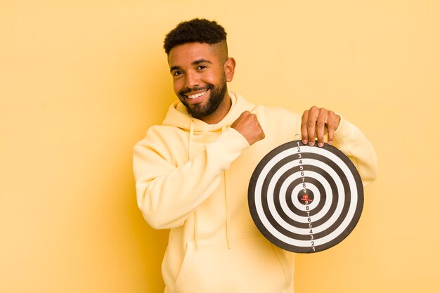 Afro cool man feeling happy and facing a challenge or celebrating dart target concept