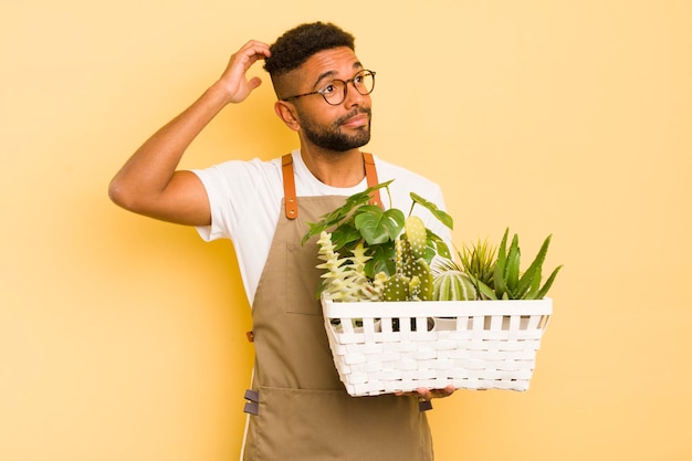 写真 頭の庭師と植物の概念を引っ掻いて困惑し、混乱している感じのアフロクールな男