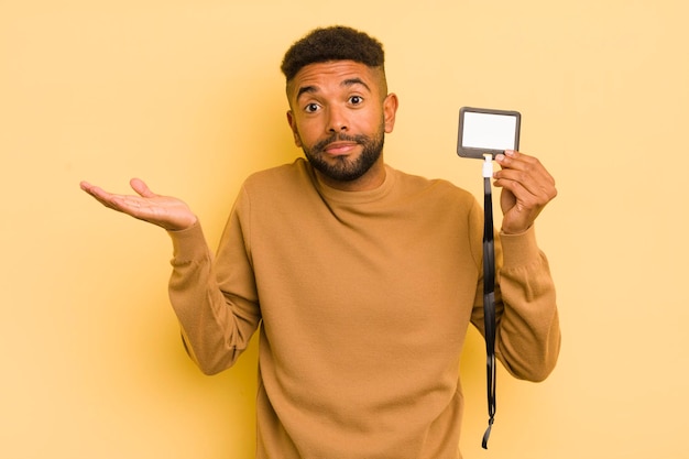 Afro cool man feeling puzzled and confused and doubting vip pass id concept