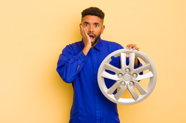 Afro cool man feeling shocked and scared bike repairman concept