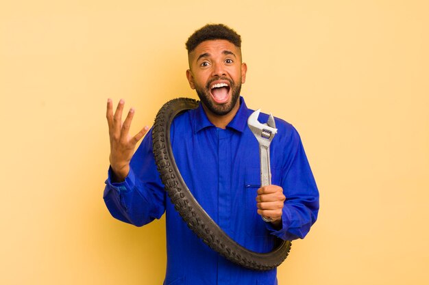 Afro cool man looking desperate frustrated and stressed bike repairman concept