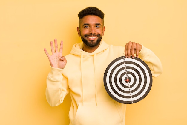 Afro cool man smiling and looking friendly showing number four dart target concept