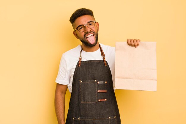 Afro cool man with cheerful and rebellious attitude joking and sticking tongue out deliveryman and fast food concept