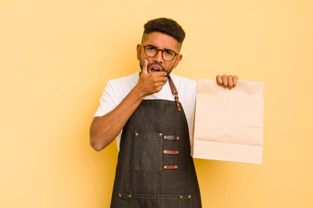 Afro cool man with mouth and eyes wide open and hand on chin deliveryman and fast food concept