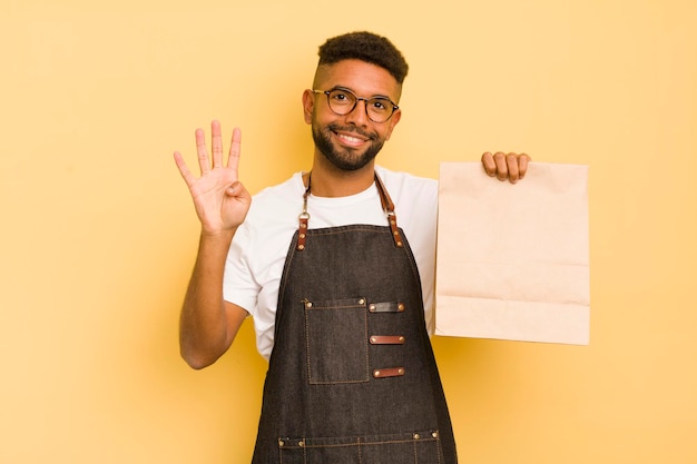 Afro-coole man die lacht en er vriendelijk uitziet met nummer vier bezorger en fastfoodconcept