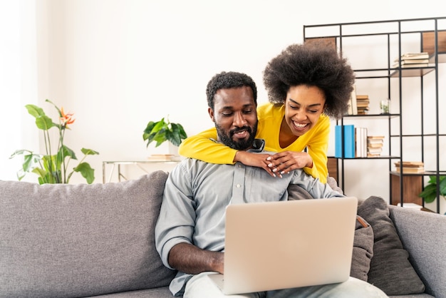 Photo afro couple using computer laptop at home